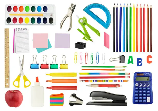 A white background featuring an assortment of colorful icons of school supplies. The supplies include a staple remover, a red apple, watercolor paints, a drawing compass, glue, scissors, a ruler, a calculator, a spiral notebook, a felt-tip pen and a protractor.