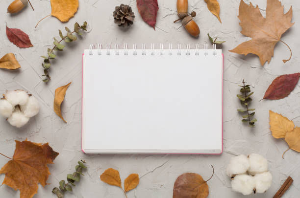 istock Autumn leaves with notebook on concrete background, top view 1737566673