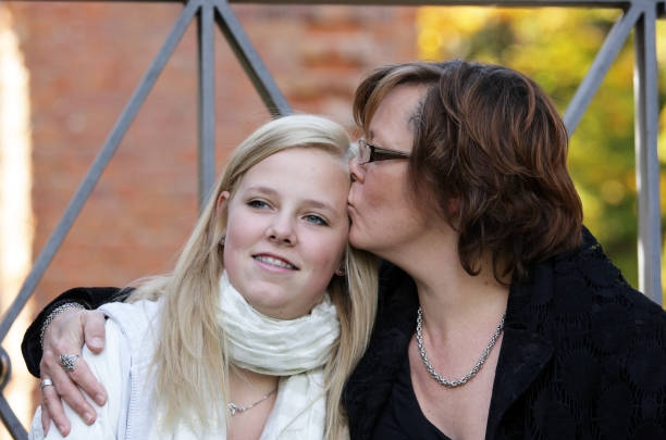 Mother kissing daughter. stock photo