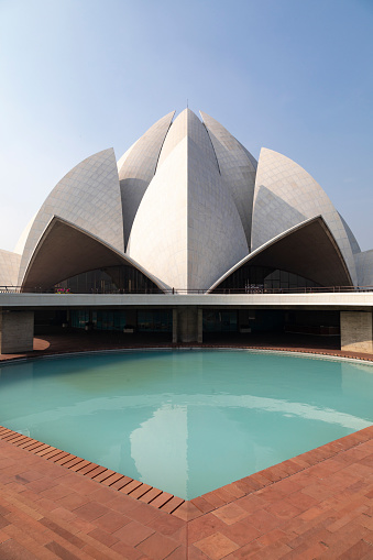 The Lotus Temple in Delhi is a Bahá'í House of Worship known for its stunning architecture, designed to imitate a lotus flower in full bloom. Composed of 27 free-standing marble petals arranged in clusters of three, the structure stands as a testament to modern architectural ingenuity and spiritual inclusivity. This image highlights the temple's remarkable design, capturing the serene atmosphere and architectural details that make it one of Delhi's most visited landmarks.