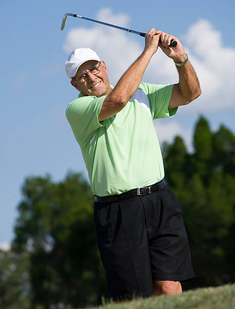 istock Senior golfer swinging iron golf club 173757346