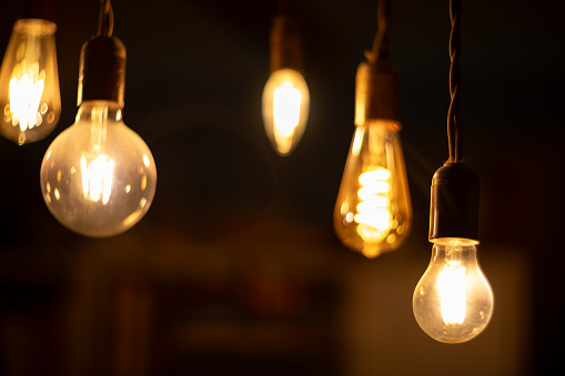 Retro LED light bulbs hanging on a dark background in interior. Electricity, Vintage