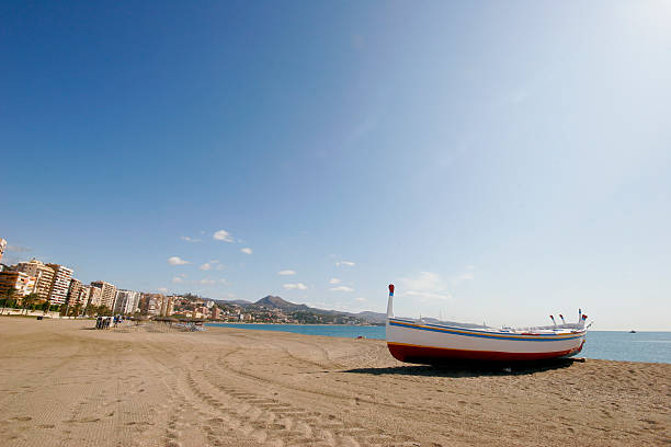 Beach at Malaga center with boat.