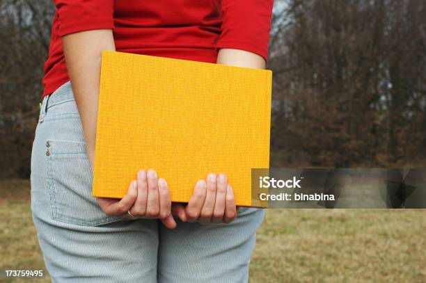 Ragazza Tiene Un Libro Giallo - Fotografie stock e altre immagini di Abbigliamento casual - Abbigliamento casual, Adolescente, Adulto