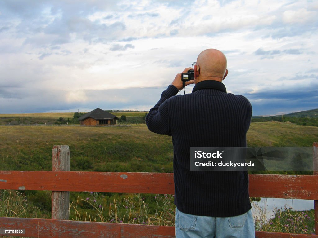 Photographer A photographer (senior man) using his digital camera. A preview of the scene is visible in the small LCD display of his camera. Montana - Western USA Stock Photo