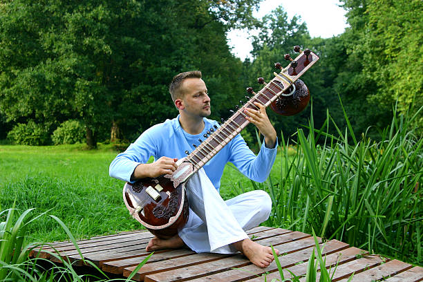 man on the breastbone with sitar stock photo