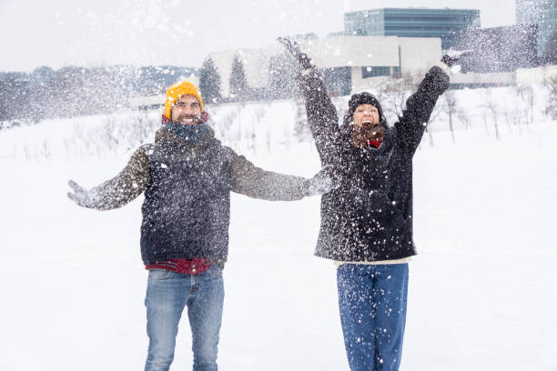Couple throwing snow and enjoying winter. stock photo