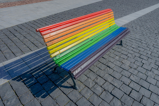 Rainbow bench painted multi colored, public park in Tui, Pontevedra, Galicia, Spain.