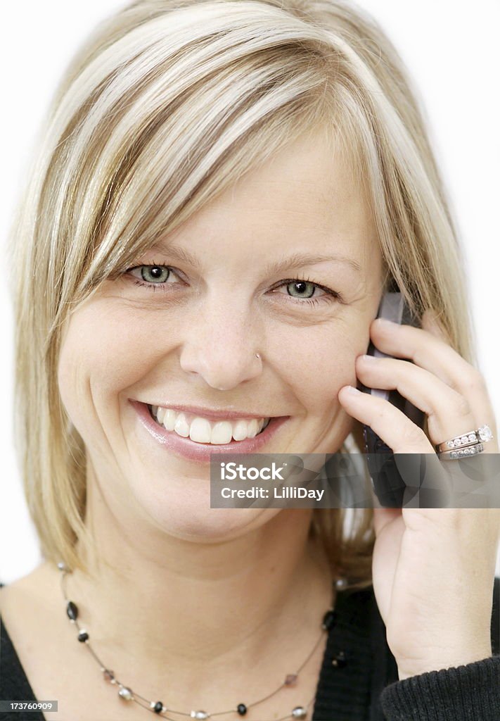 Donna sorridente sul telefono cellulare - Foto stock royalty-free di Adulto