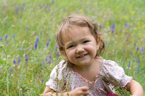 Smiling little girl on the meadowFor more photos and videos of children and flowers click here