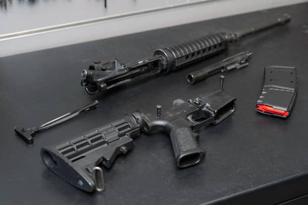 Disassembled weapon and an ammunition magazine on a black desk in a shooting range