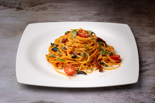 Making a fresh delicious Italian pasta, spaghetti with tomato sauce, garlic, basil and spices