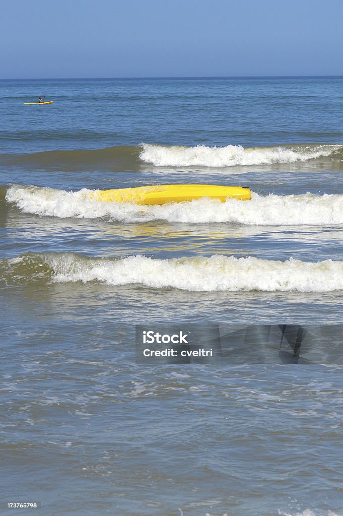 Kayak Flipped In The Ocean Kayak flipped by ocean waves. Aquatic Sport Stock Photo