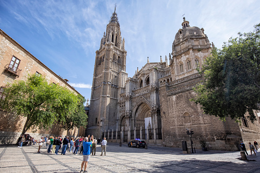 Exterior view of Toledo Cathedral, Spain. Many tourists and a police car can be seen.