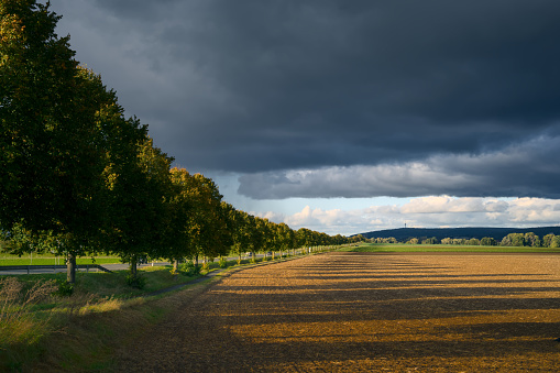 landscape in autumn, dark clouds and golden sun over agrultural fields near Göttingen, Germany