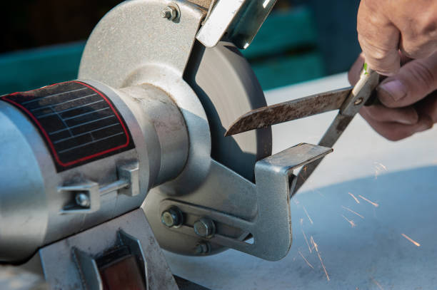 istock Manual sharpening of scissors using hand tools. Circumcised Hands Of An Unknown Person Sharpening Scissors On A Typewriter. man sharpens scissors 1737681470