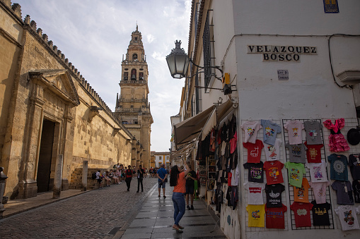 Street outside of the Great Mosque of Córdoba, Spain. A souvenir shop and many tourists can be seen.