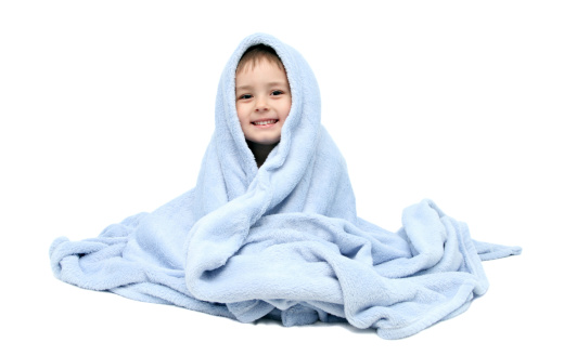 Child after bath sitting on bed