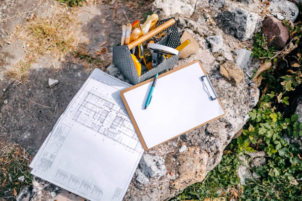 College students working at old historical archeology field looking at plan