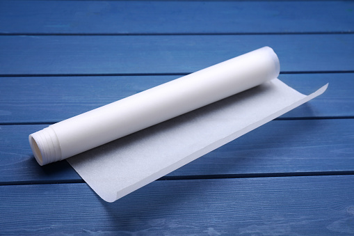 Roll of baking paper on blue wooden table