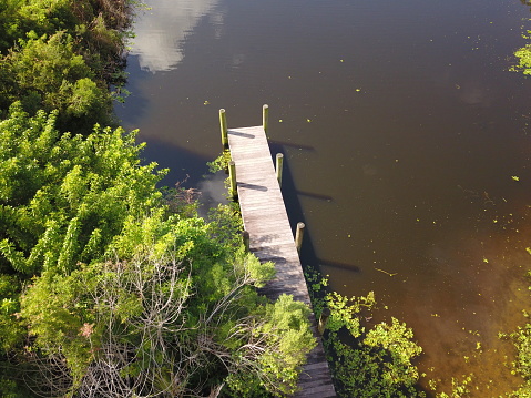 An aerial drone photo of a wooden dock to your favorite lake, by photographer Anita Denunzio.