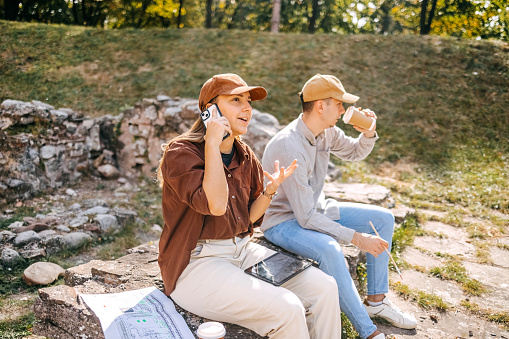 Two young colleagues taking a break after working at archeology field