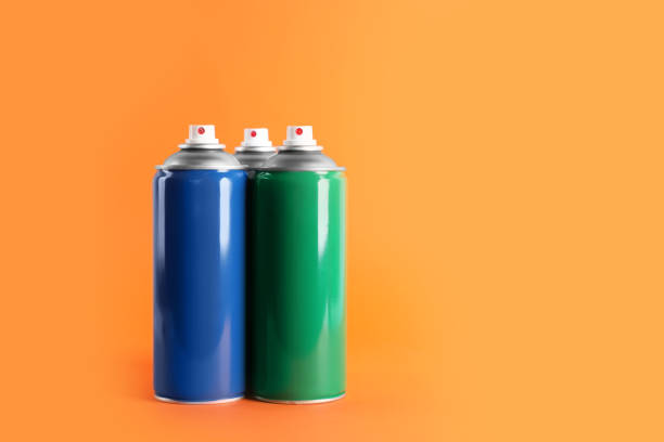 istock Colorful cans of spray paints on orange background. Space for text 1737715411