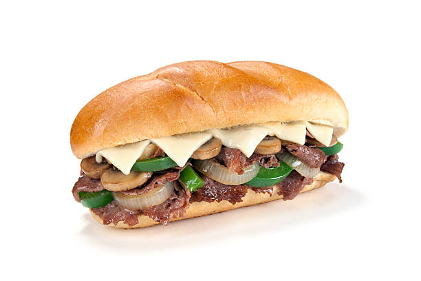 Fully Loaded Philly Cheese Steak Sandwich Aspirational shot of a fully loaded Philly cheese steak sandwich with peppers, onions, mushrooms, and cheese, isolated on white with shadow. submarine sandwich photos stock pictures, royalty-free photos & images