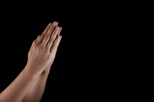 istock Woman holding hands clasped while praying on black background, closeup. Space for text 1737728295