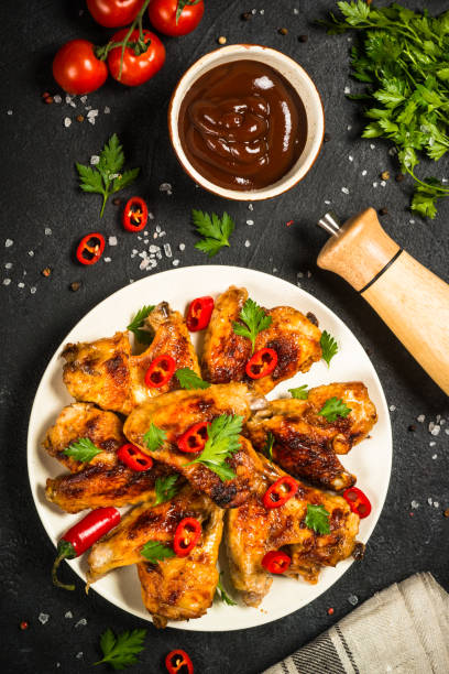 istock Grilled chicken wings at black. 1737739292