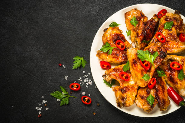 istock Grilled chicken wings at black. 1737739293