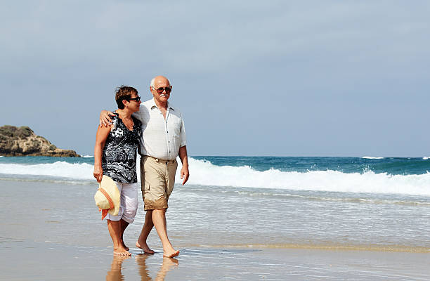 istock Happy senior couple walking together on a beach 173775796