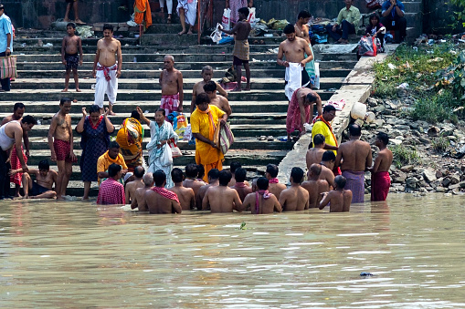 Kolkata, India - October 14, 2023 : Unknown People crowd at early morning in the shore of River Ganga to take part in the Hindu ritual called 'Tarpana' at Ahiritola ghat, North Kolkata in Mahalaya. 
Tarpaṇa  is a term in the Vedic practice that refers to an offering made to divine entities. It refers to the act of offering as well as the substance used in the offering. Tilatarpana is a specific form of tarpana involving libations offered to the pitri (deceased ancestors) using water and sesame seeds during Pitru Paksha or as a death rite.
