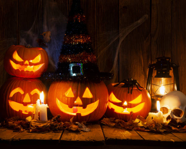 Halloween Jack-o-Lantern Pumpkins on rustic wooden background stock photo
