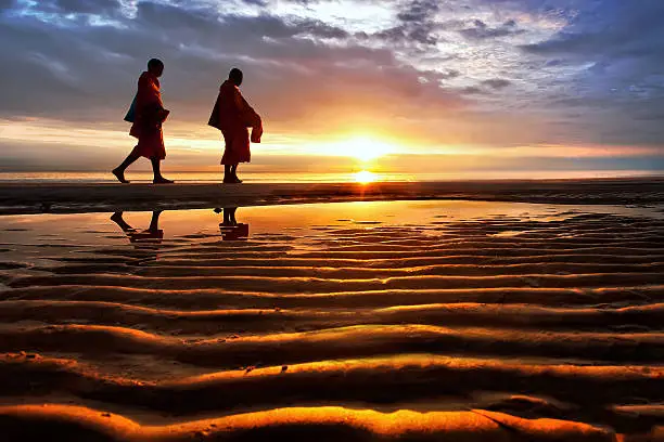 Photo of Silhouettes of monks on Hua Hin beach Thailand