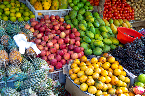 This image showcases a bustling fruit and vegetable stall in Goa, a popular tourist destination known for its beaches and vibrant local culture. The stall is abundant with a variety of fresh produce, ranging from tropical fruits like mangoes and bananas to an array of local vegetables. Colours pop in a vivid display, capturing the freshness and diversity of the items on offer. The photograph aims to give viewers a sense of the local food scene, where freshness and variety are paramount, encapsulating the essence of daily life and commerce in Goa.