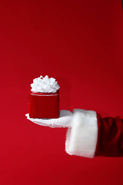 Santa segurando um Presente de Natal de vermelho e branco - fotografia de stock