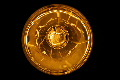Close up view of a lighting electric bulb with reflections.