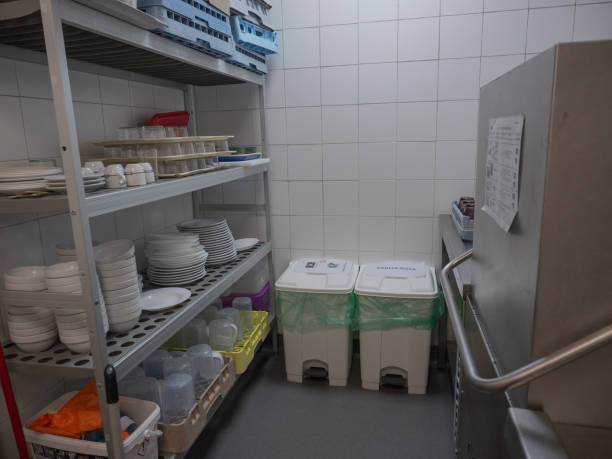 many dish or white plate arranged on basket for cleaning by automatic dishwasher machine in kitchen room restaurant