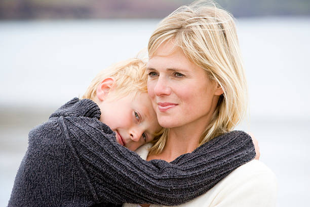 istock Mother holding son at beach smiling 173781491