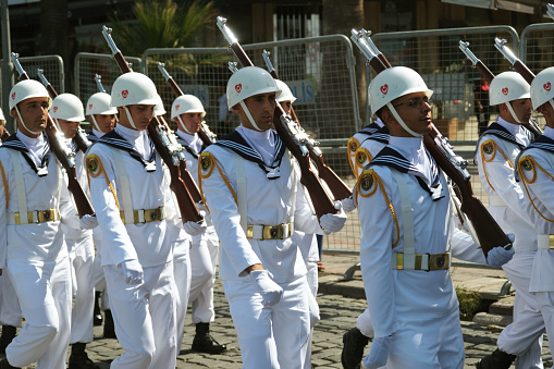 Izmir, Turkey - August 30, 2023: A contingent of naval personnel in pristine white uniforms and helmets march with precision during the Victory Day parade.