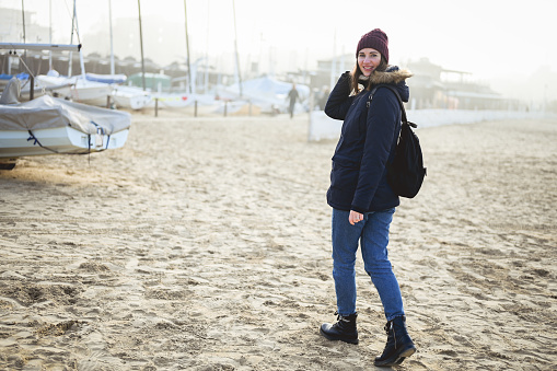 backpacker tourist in a sandy beach in winter time.
