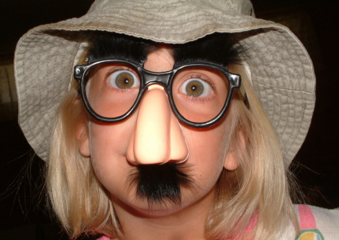 photo of a girl wearing a groucho mask. dark backgroud. For more like this checkout