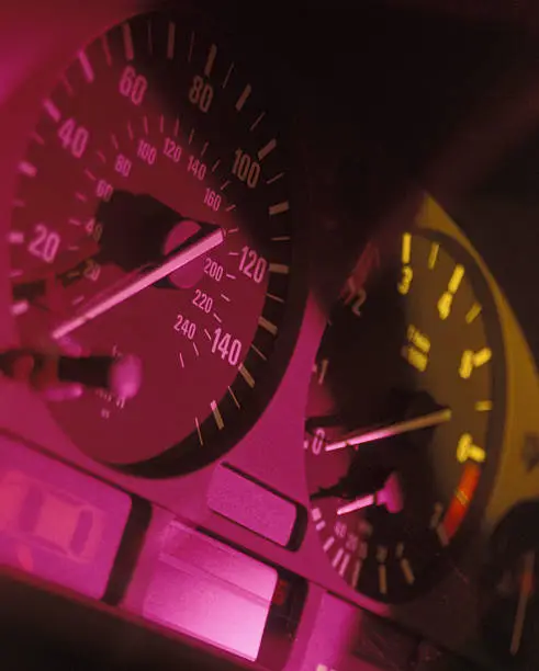 The spedometer and tachometer on a BMW 528i.  Shot on 35mm slide film for maximum quality, using gelled lights for effects.