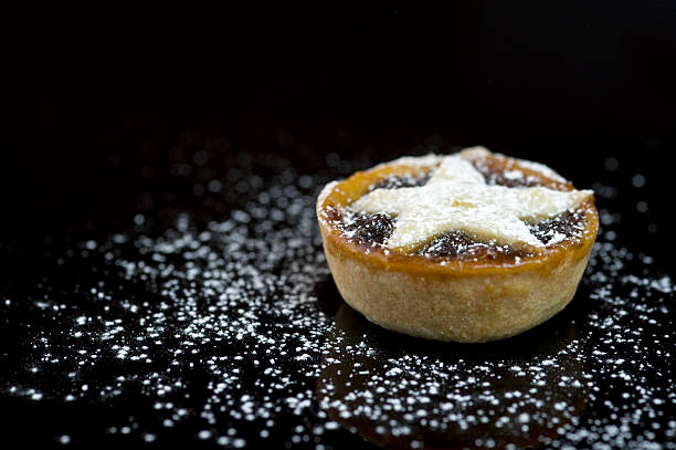 Single Christmas mince pie on black background stock photo