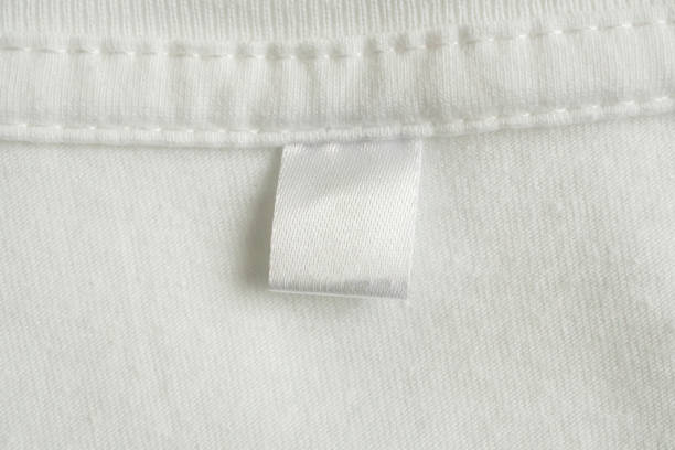 istock Blank white laundry care clothes label on white shirt fabric texture background 1738001928