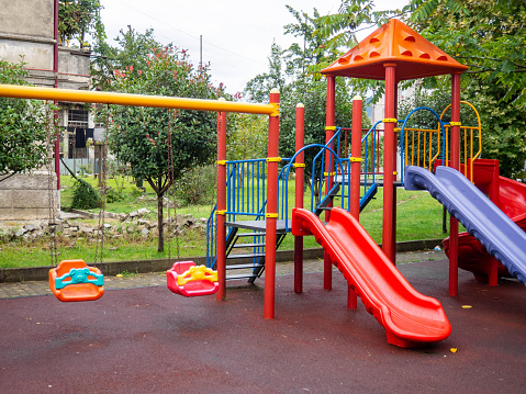 Plastic playground. Safe game for children. City infrastructure. Swings and slides made of plastic. Entertainment. Playground in the yard. Spiral slide