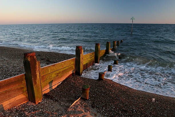 A view towards Fairlight Cliffs taken at ground level so the wet sand reflects the sky.