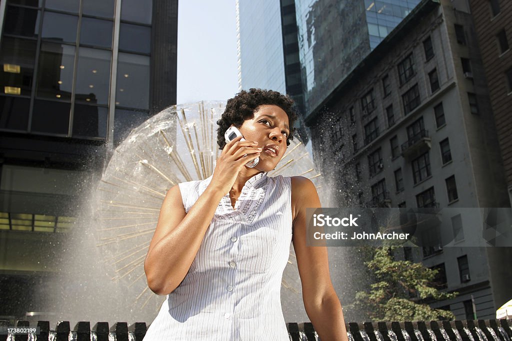 Young Woman On Her Mobile Phone "A beautiful, confident young woman on the mobile phone in front of a Manhattan city fountain. Taken during the iStock NYC Photo Shoot of September 13, 2005." Adult Stock Photo