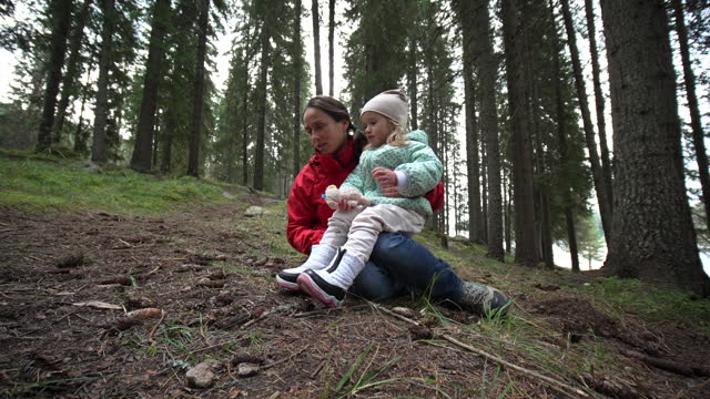 Family camping. Mom and kid hike in the forest.